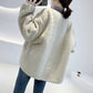 Manteau court en fourrure d'agneau lâche et coutures assorties